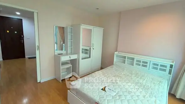 Spacious bedroom with modern white furniture and hardwood flooring