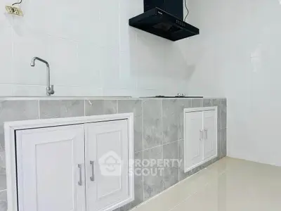 Modern minimalist kitchen with sleek cabinetry and built-in stove, perfect for contemporary living.