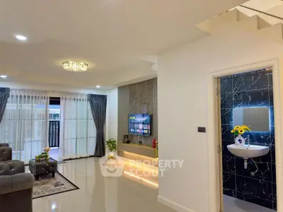 Modern living room with elegant decor and open layout, featuring a stylish TV wall and access to a balcony.