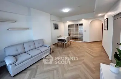 Spacious living room with modern decor and herringbone flooring, perfect for relaxation and entertaining.