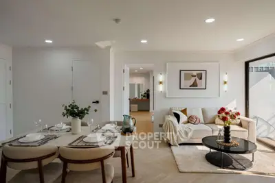 Modern living room with elegant dining area and stylish decor, featuring natural light and contemporary furnishings.