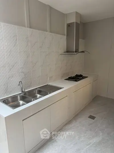 Modern kitchen with sleek white cabinetry and gas stove