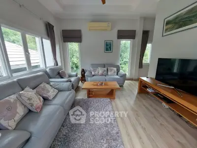 Spacious living room with modern decor and large windows offering natural light.
