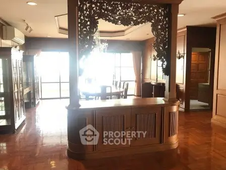Spacious living room with elegant wooden decor and large windows offering natural light.
