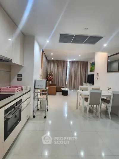 Modern open-layout kitchen and living room with sleek design and natural light.