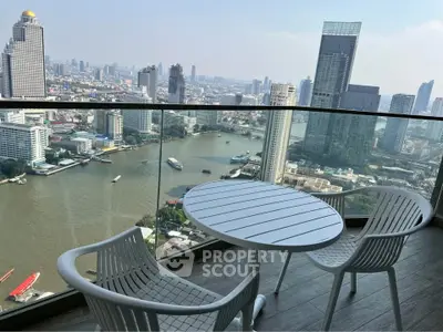 Stunning city and river view from a high-rise balcony with modern seating.