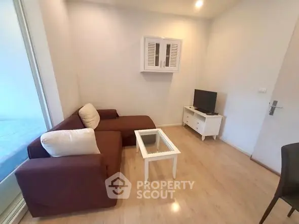 Cozy living room with modern brown sofa and glass coffee table, perfect for relaxation.