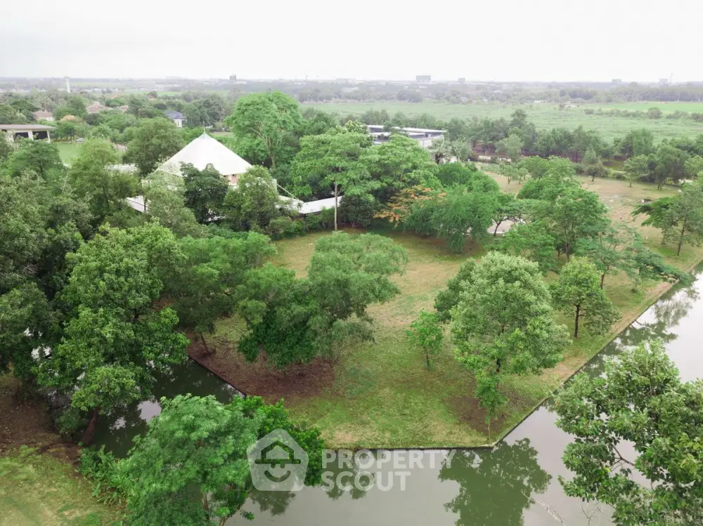 Expansive lush green garden with serene water view in prime real estate location