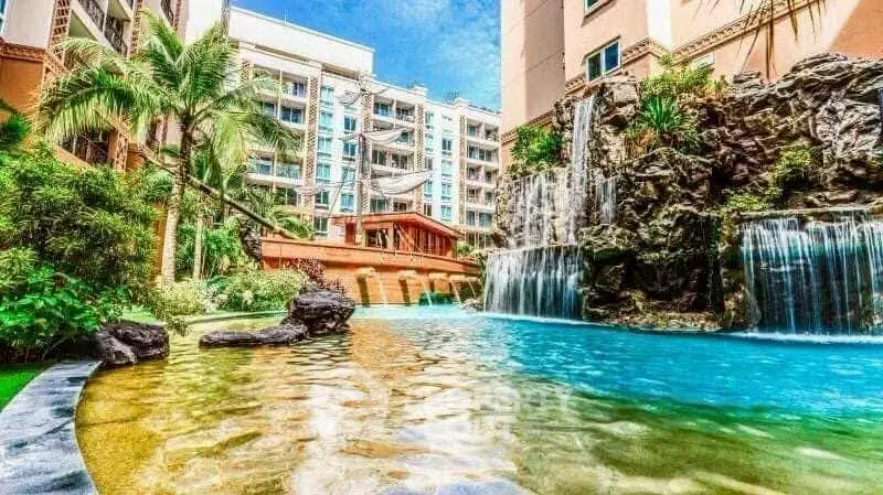 Luxurious residential complex with stunning pool and waterfall feature.