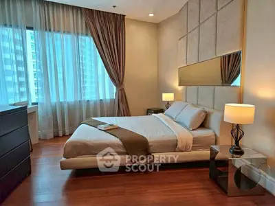 Luxurious bedroom with modern decor and large window in high-rise apartment.