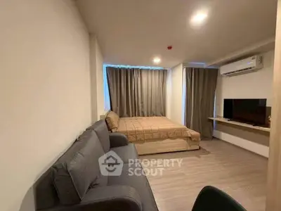Modern studio apartment with cozy living area and stylish furnishings.
