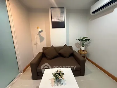 Cozy living room with modern decor, featuring a comfortable sofa, stylish lamp, and air conditioning.