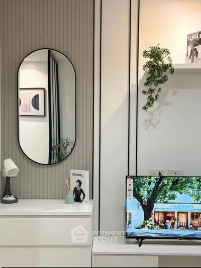Modern living room with stylish decor, featuring a wall-mounted TV and elegant mirror.