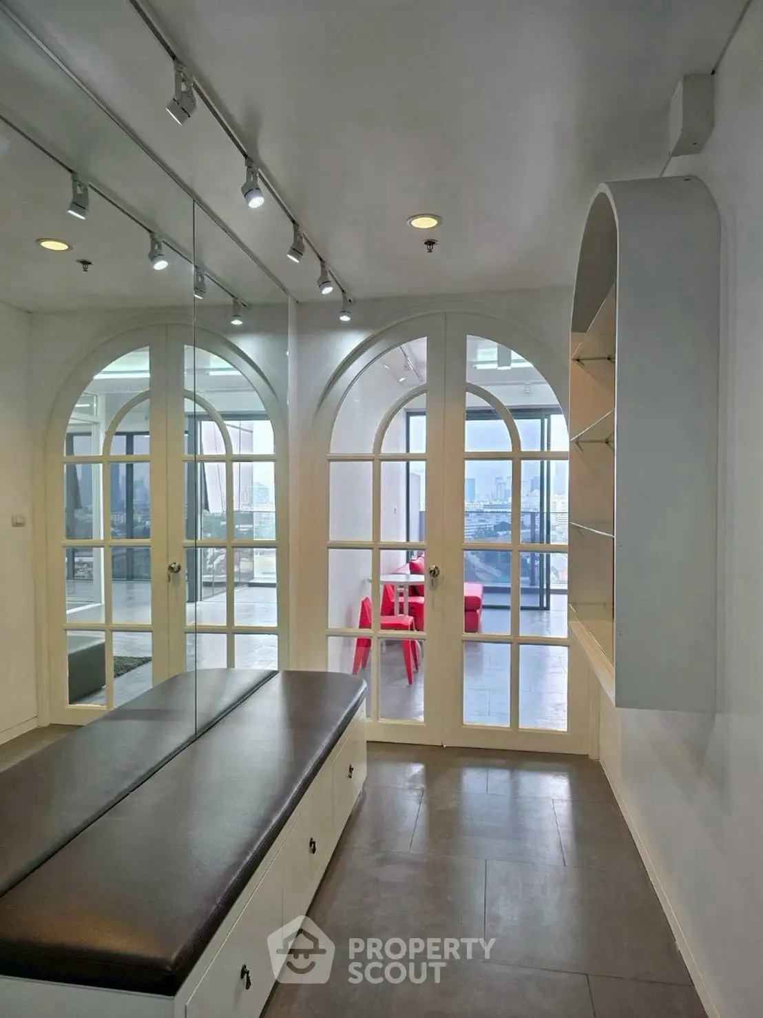 Elegant interior with arched windows and modern decor, offering a glimpse of a stylish dining area.