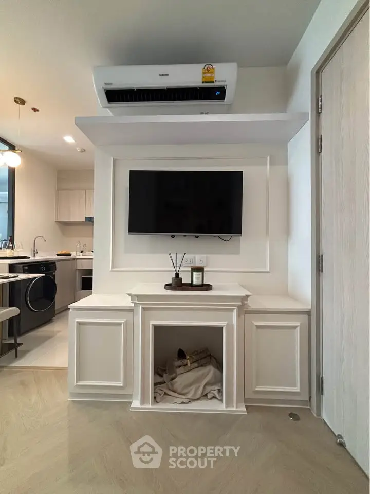 Modern living room with sleek TV setup and stylish kitchen in open layout
