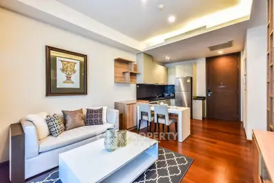 Modern living room with open kitchen, stylish decor, and hardwood floors in a cozy apartment.