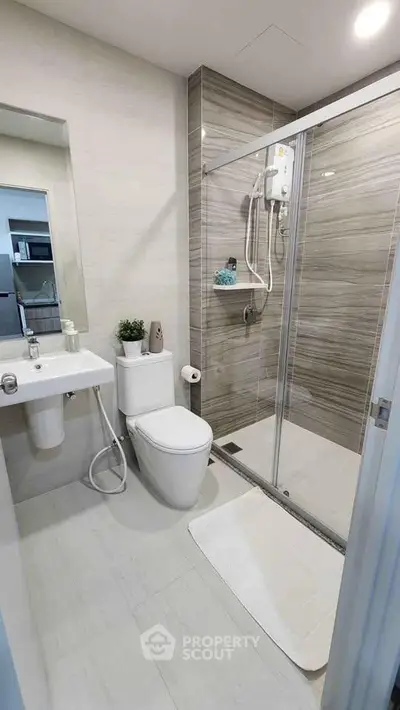 Modern bathroom with sleek shower and contemporary fixtures in a stylish apartment.