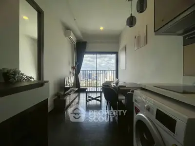 Modern apartment with city view, featuring a compact living area and in-unit washing machine.