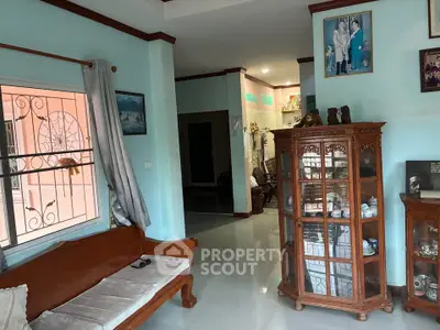 Charming living room with elegant wooden furniture and decorative display cabinet, perfect for cozy family gatherings.