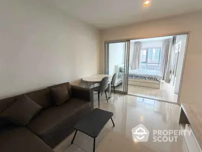 Modern apartment with open living room and bedroom layout, featuring sleek furniture and ample natural light.