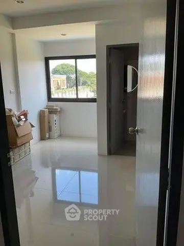 Bright room with glossy white tiles and large window offering natural light, ideal for customization.