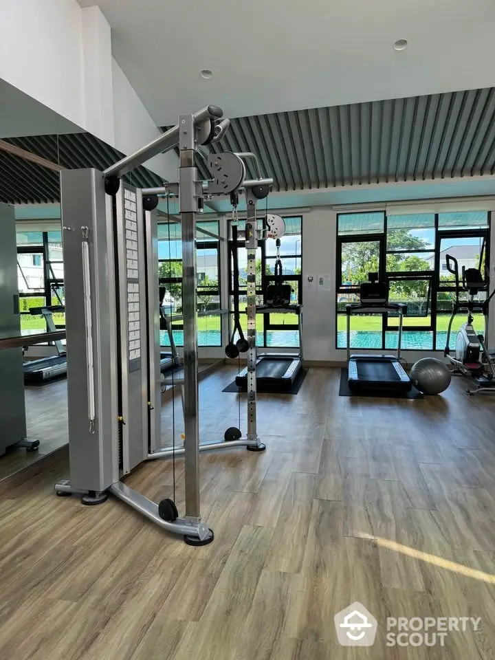 Modern gym with state-of-the-art equipment and scenic outdoor view, perfect for fitness enthusiasts.