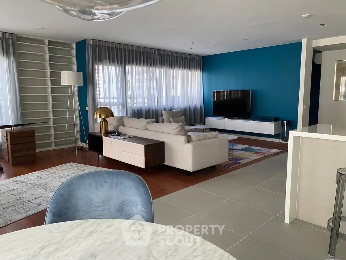 Spacious modern living room with stylish decor and large windows.