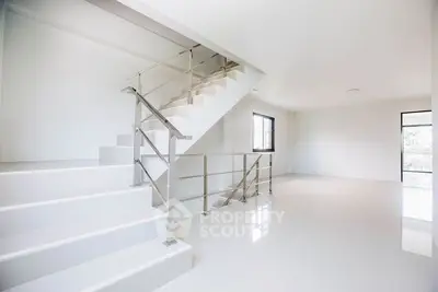 Spacious modern interior with sleek staircase and large windows