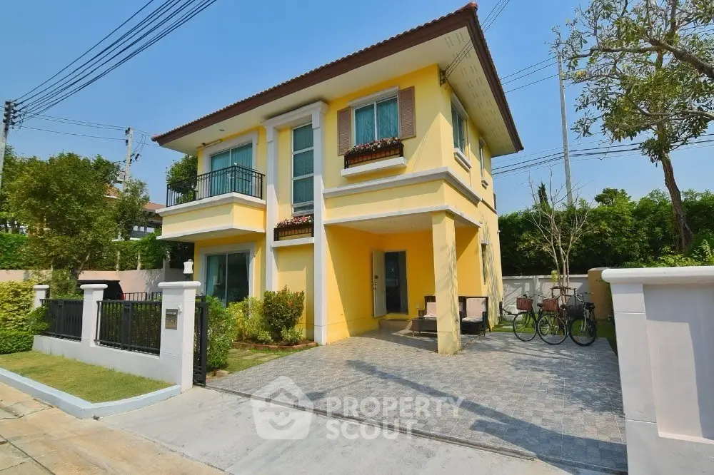 Charming two-story yellow house with driveway and lush greenery