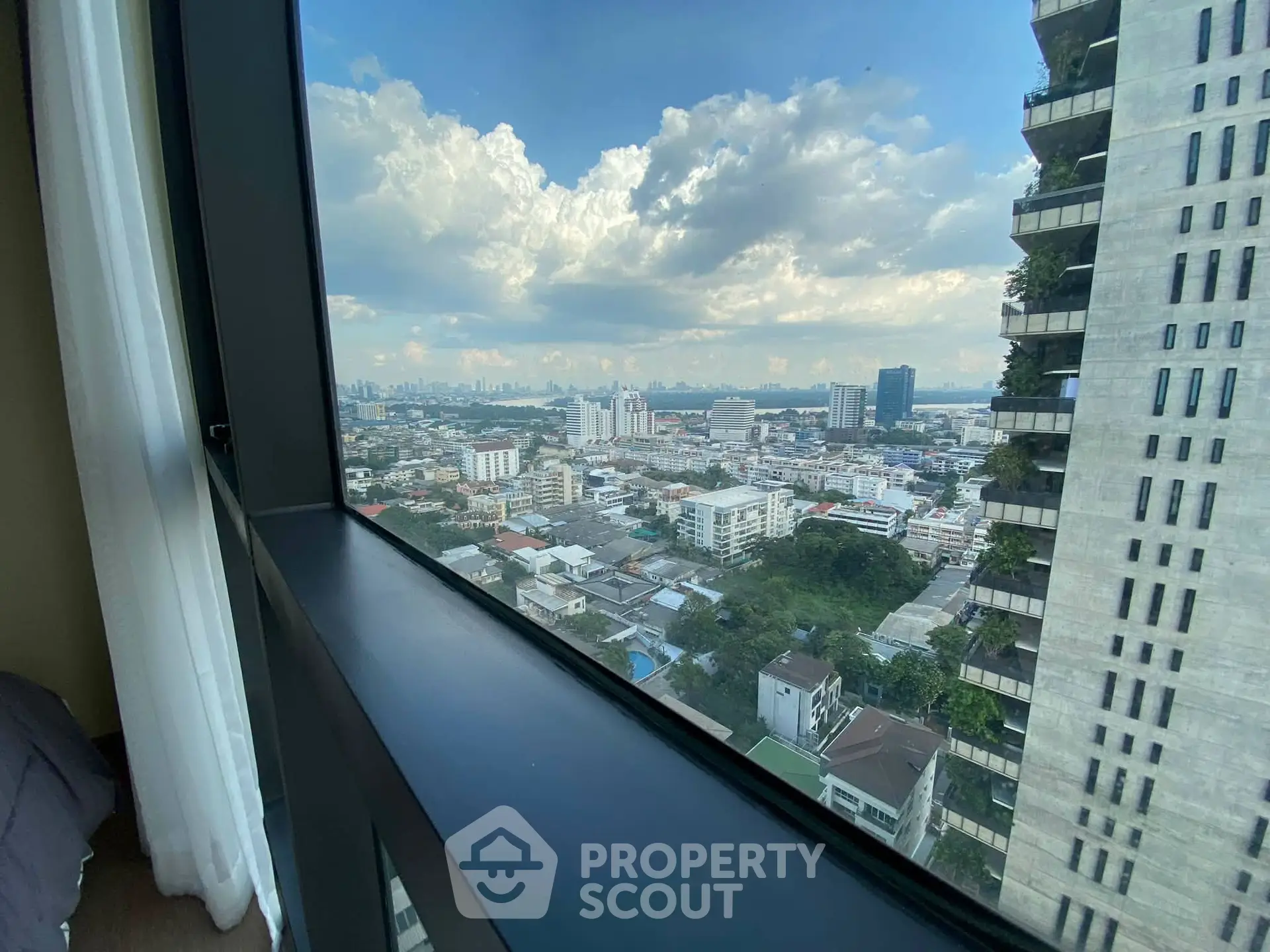 Stunning cityscape view from high-rise apartment window with expansive skyline and modern architecture.