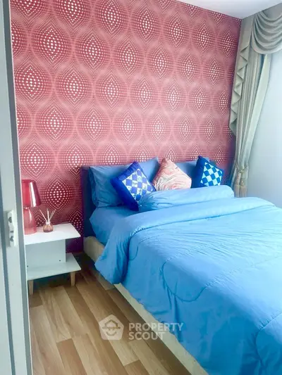 Stylish bedroom with vibrant wallpaper and cozy blue bedding