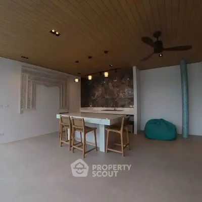 Modern open-layout kitchen with stylish bar seating and unique ceiling design