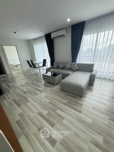 Spacious modern living room with elegant decor and large windows offering ample natural light.