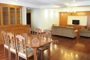 Spacious living and dining area with elegant wooden furniture and cozy seating.