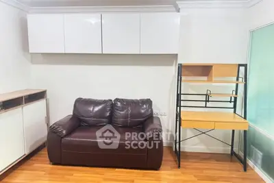 Cozy living room with leather sofa and modern wooden desk, perfect for relaxation and work.