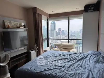 Modern bedroom with stunning city view and cozy seating area
