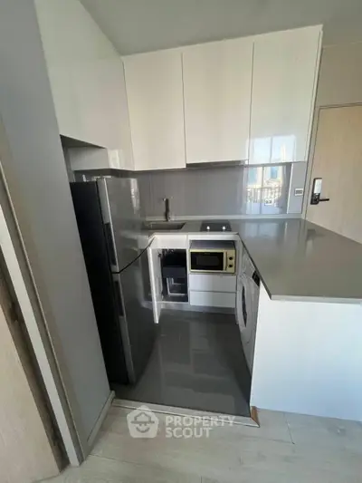 Modern compact kitchen with sleek appliances and glossy cabinets