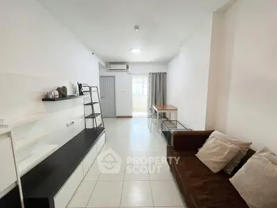 Spacious living room with modern decor and natural light in a stylish apartment.