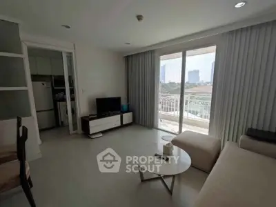Spacious living room with modern decor and balcony view in a high-rise apartment.