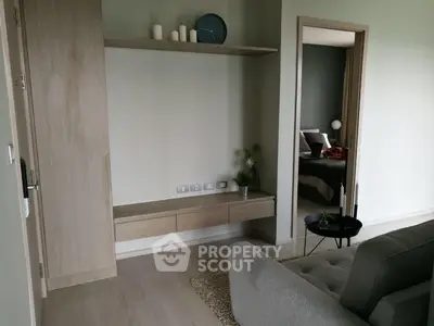 Modern living room with sleek furniture and open doorway to bedroom