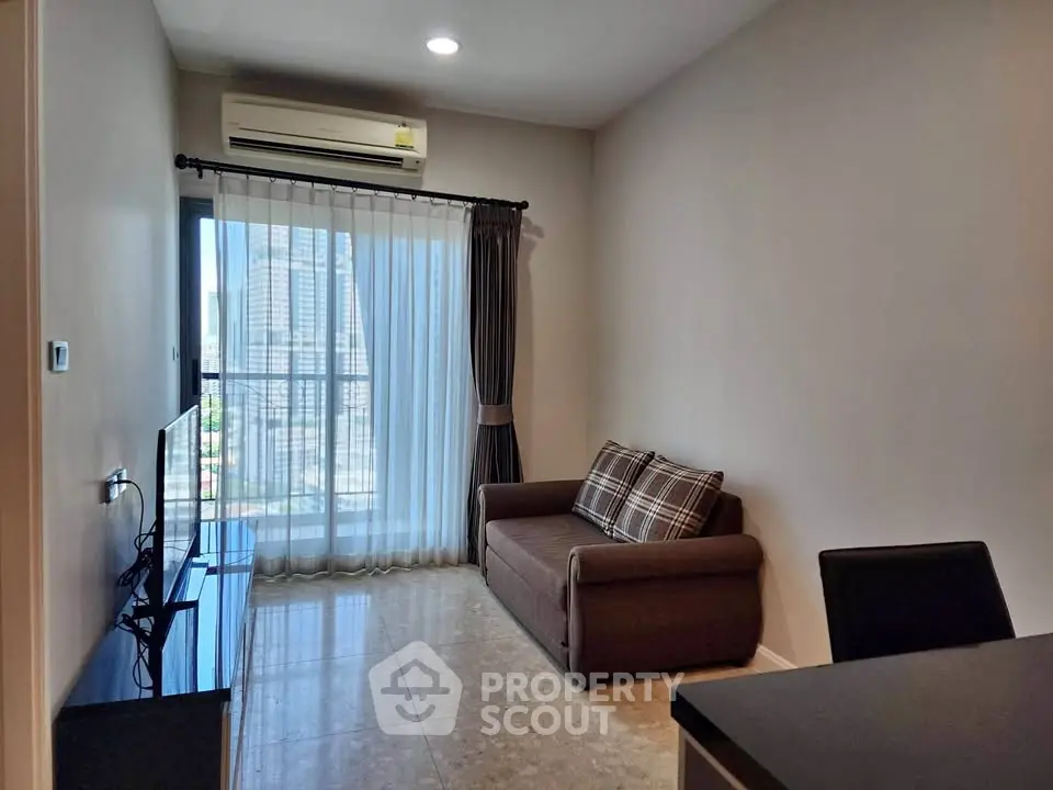 Modern living room with city view, featuring a cozy sofa and sleek TV setup.