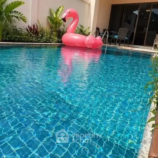 Luxurious private pool with inflatable flamingo, perfect for relaxation and entertainment.