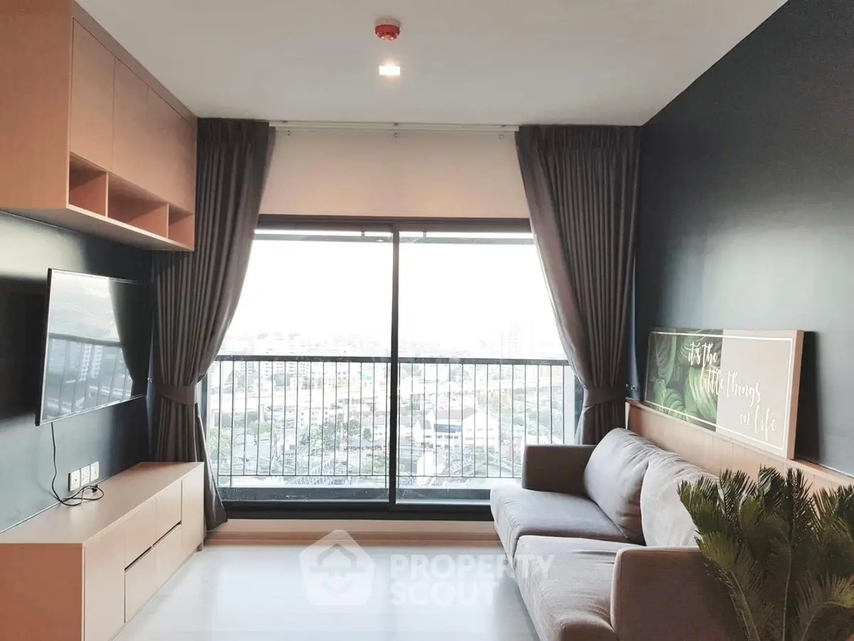 Modern living room with large window and city view, featuring sleek furniture and stylish decor.