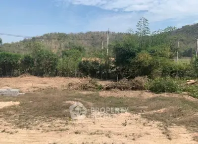 Expansive plot of land with scenic mountain backdrop, ideal for development opportunities.