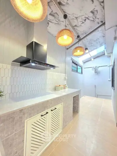 Modern kitchen with stylish lighting and sleek cabinetry, featuring a bright and airy design.