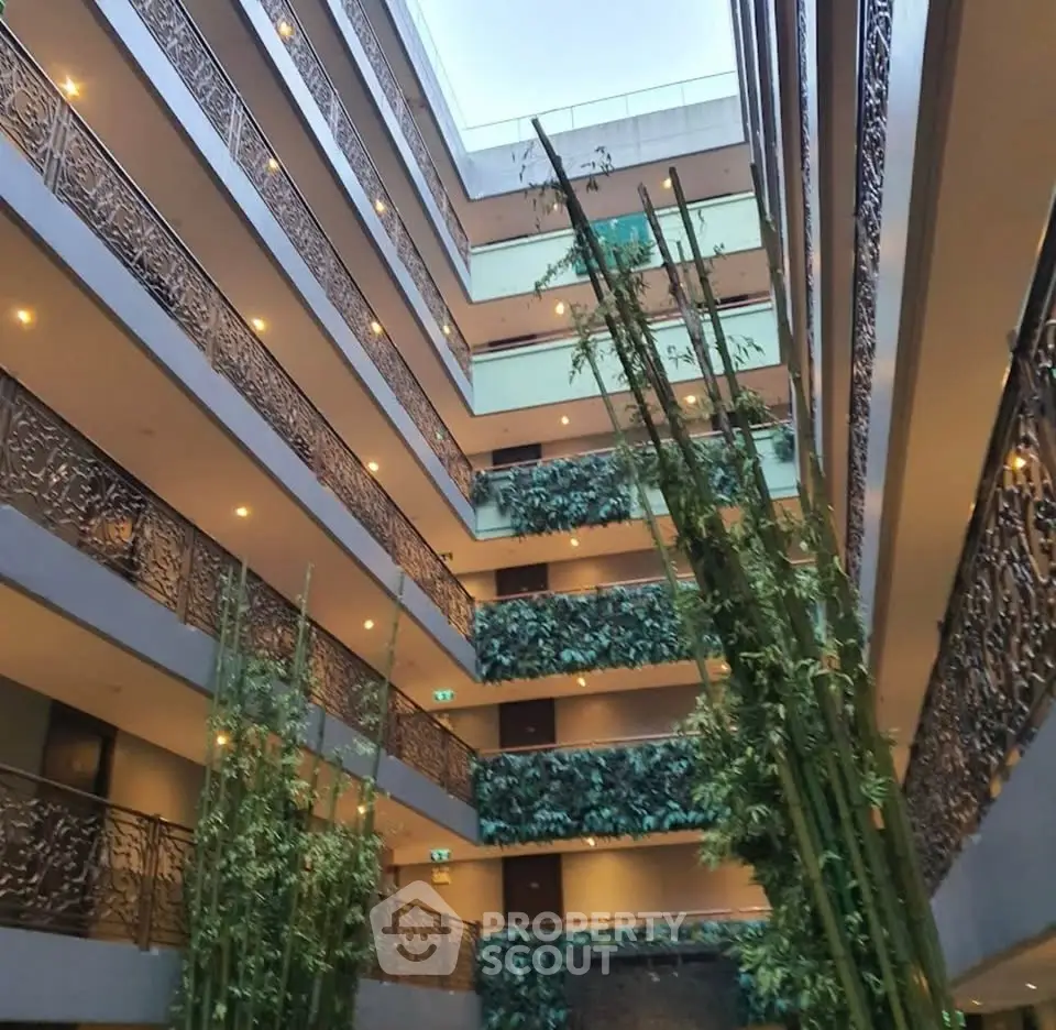 Stunning multi-story building interior with lush greenery and intricate railing designs.
