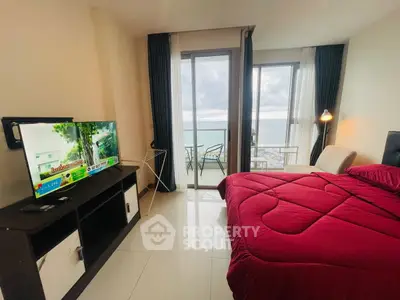 Modern bedroom with ocean view and balcony access, featuring sleek furniture and vibrant decor.