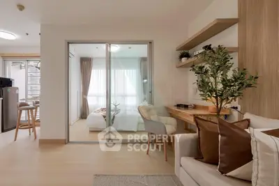 Modern apartment interior with cozy living room and stylish bedroom separated by glass doors.