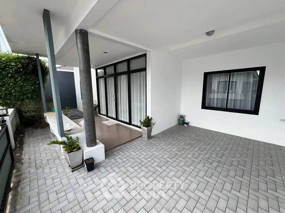 Modern home exterior with spacious tiled patio and large windows