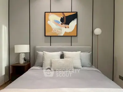 Elegant bedroom with modern decor and stylish artwork, featuring a cozy bed and ambient lighting.
